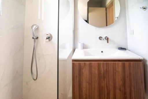 Modern bathroom with round mirror and shower fixtures