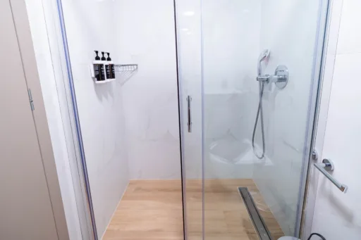 Glass shower enclosure with wall-mounted dispensers