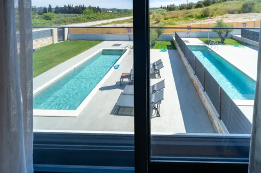 Lush garden and pool view at Villa Fos in Poseidi from bedroom's balcony