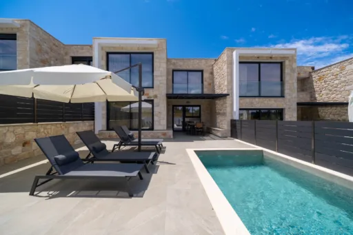 Exterior view of the pool and garden at Villa Iris in Poseidi
