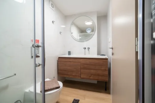 Ground-floor bathroom with wooden vanity and large mirror