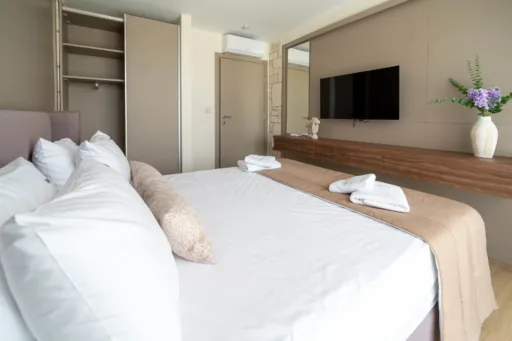 Spacious bedroom with modern furnishings and smart tv