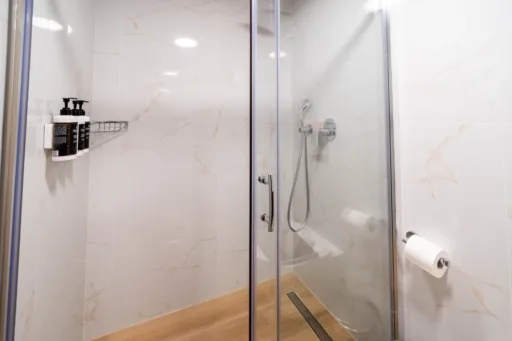 Bright second bathroom with glass shower enclosure