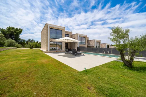 Garden area with lawn and outdoor seating next to the villa