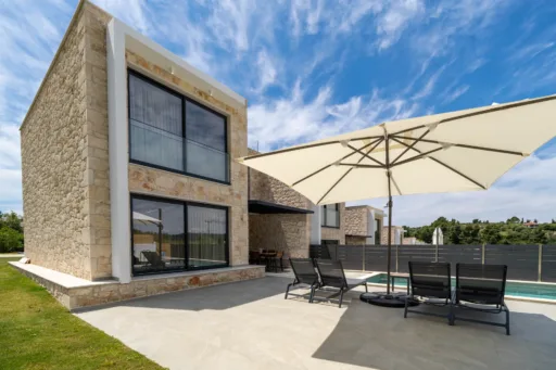 Private pool with stone terrace and sun loungers at Villa Theros in Poseidi