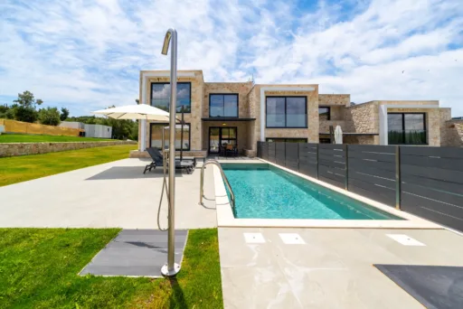 Wide exterior view of the landscaped garden and pool at Villa Theros, Halkidiki