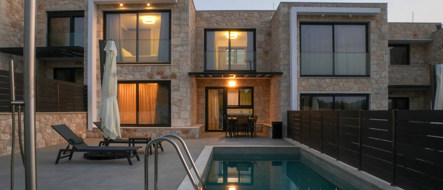 The illuminated private pool and outdoor dining area of our villas at night